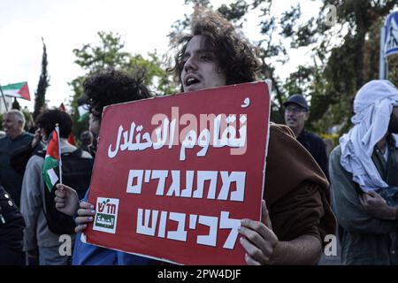 Ost-Jerusalem, Israel. 28. April 2023. Ein israelischer linker Aktivist hält während der wöchentlichen Demonstration ein Plakat, auf dem er seine Meinung zum Ausdruck bringt . Eine Demonstration gegen die Räumung der Palästinenser aus ihren Häusern in der Nachbarschaft von Scheich Jarrah im israelisch annektierten Ost-Jerusalem. Kredit: SOPA Images Limited/Alamy Live News Stockfoto