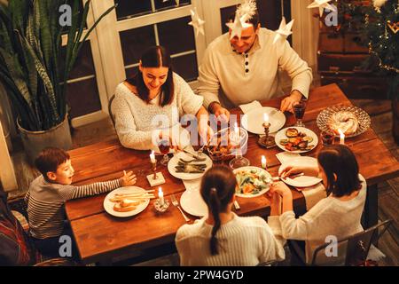 Blick von oben auf eine glückliche große Familie mit vielen Kindern, die Weihnachten oder Silvester zusammen in einem gemütlichen, warmen Zuhause feiern, um festlich zu feiern Stockfoto