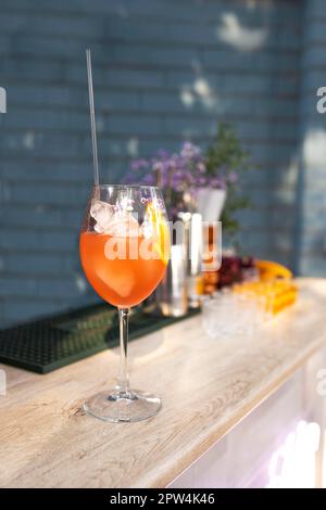 Aperol Spritz Cocktail in Glas mit frischem Orange und Eis auf blauem Hintergrund. Details zur Sommerparty im Freien Stockfoto