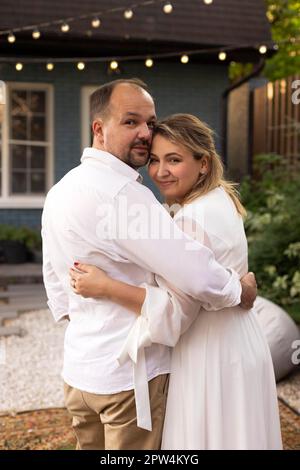 Mittelalterliches Hochzeitspaar, das romantische Momente draußen in einem Sommergarten genießt. Gemütliches Zeremoniekonzept. Hochzeitstag Stockfoto