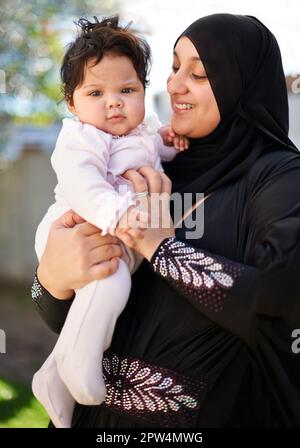 Sie wird jeden Tag größer. Eine muslimische Mutter und ihr kleines Mädchen Stockfoto