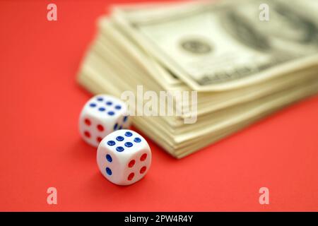 Geld-, Finanz- und Glücksspielkonzept. Nahaufnahme eines amerikanischen Hundert-US-Dollar-Banknotenscheines und zwei weiße Würfel auf der Oberseite, die die Zahlen sechs und sechs zeigen Stockfoto