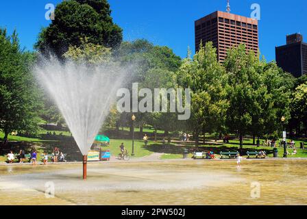 An einem Sommertag im Boston Common sprüht ein Sprinkler über den Froschteich Stockfoto