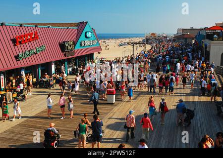 An einem wunderschönen sonnigen Sommerurlaub in Point Pleasant an der Jersey Shore drängen sich die Leute auf die Promenade Stockfoto