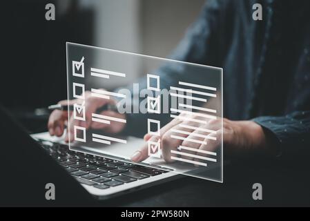 Mann mit Laptop-Fragebogen mit Kontrollkästchen, Umfrageformular online, Fragen in der Prüfung der Prüfliste und Ausfüllen des Umfrageformulars onli Stockfoto