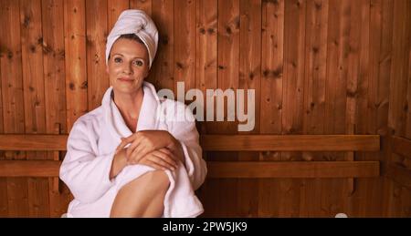 Genießen Sie die einfachen Dinge im Leben. Eine reife Frau in der Sauna Stockfoto