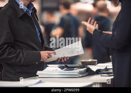 Geschäftsleute tauschen Werbematerial und Broschüren über Geschäftstreffen auf Messen aus. Geschäftsgespräch Geschäftskonzept Stockfoto