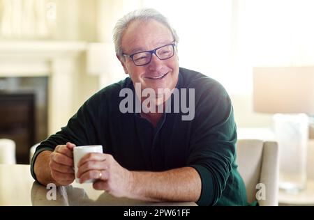 Es geht nichts über eine Tasse Kaffee am Morgen. Ein älterer Mann, der sich zu Hause entspannt. Stockfoto