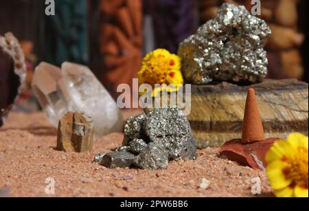 Gelbe Blumen mit Pyritfelsen und Kristallen auf dem australischen roten Sand Stockfoto