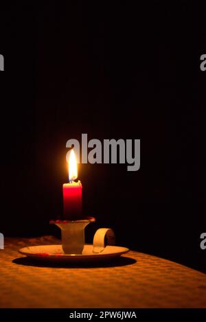 Kerzenlicht auf eine Tabelle, in der Dunkelheit. Stromausfall, blackout Konzept Hintergrund. Stockfoto