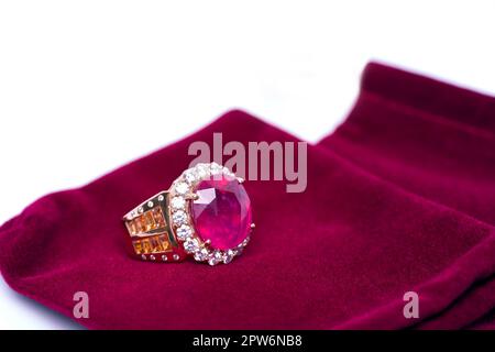 Burma Ruby mit orangefarbenen Saphiren und weißem Quarzring auf rotem Samtbeutel. Sammlung von Accessoires für natürliche Edelsteine. Studioaufnahme Stockfoto