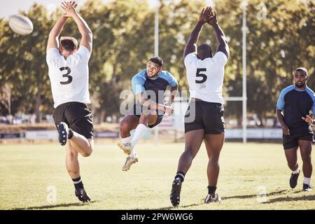 Rugby-Spieler mit gemischten Rassen versucht während eines Rugby-Spiels draußen auf dem Spielfeld einen dropkick. Hispanischer Mann, der für Berührung tritt oder versucht, drei P zu erreichen Stockfoto