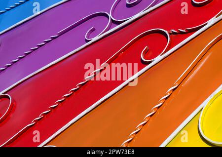 Metall Textur eines Stück farbige Wand mit einem geschmiedeten Muster. Regenbogen Farben Stockfoto