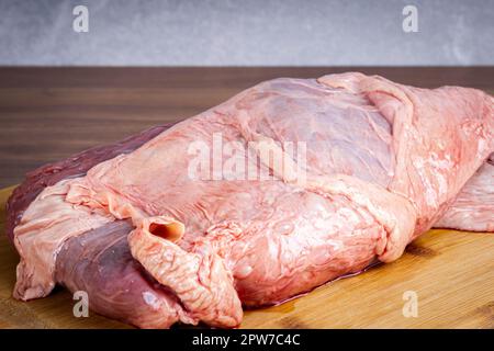 FLANK STEAK Beef BBQ Essen. Rohes Fleisch mit Fettüberzug auf Holzbrettern auf grauem Hintergrund. Stockfoto