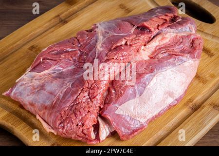 FLANK STEAK Beef BBQ Essen. Rohes Fleisch mit Fettüberzug auf Holzbrettern auf grauem Hintergrund. Perspektivische Ansicht. Stockfoto