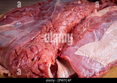 FLANK STEAK Beef BBQ Essen. Rohes Fleisch mit Fettüberzug auf Holzbrettern auf grauem Hintergrund. Ansicht schließen. Stockfoto