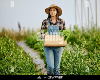 Aufnahme einer jungen Landwirtin mit frisch geernteten Produkten. Stockfoto