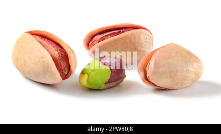 Drei Türkischen Roten Pistazien, geröstet und eines teilweise geschält grüne Mutter auf weißem Hintergrund Stockfoto