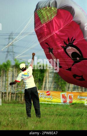 Ein Teilnehmer fliegt während des 2004. Jakarta International Kite Festivals, das am 9-11. Juli am Karnaval (Karneval) Beach in Ancol Dreamland, North Jakarta, Jakarta, Indonesien stattfindet, einen Luftballondrachen. Stockfoto