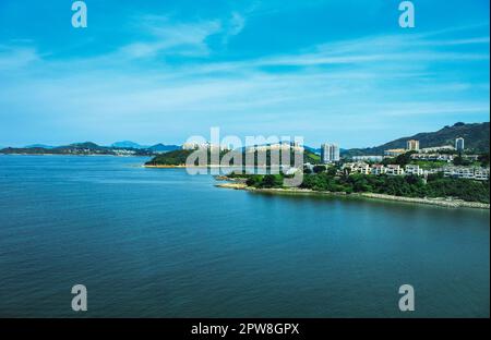 Der Blick auf die ruhige blaue Meereslandschaft mit den Inseln unter dem blauen Himmel in Hongkong. Reiseszene. Stockfoto
