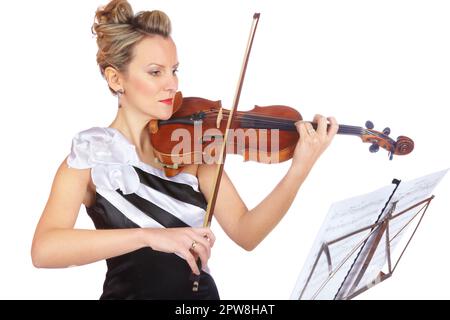 Kunst, Frau, die Violine im Studio spielt, mit Noten, professioneller Orchestermusiker auf weißem Hintergrund. Fokus, Talent und klassische Leistung Stockfoto