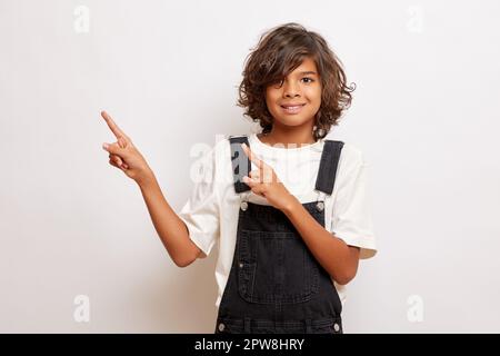 Der junge gutaussehende Kerl zeigt die Finger zweier Hände im Werberaum, isoliert. Hochwertiges Foto Stockfoto