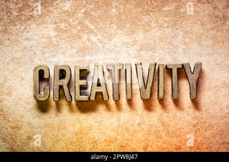 Kreatives Wort aus Metallic-Buchstaben auf Grunge-Hintergrund Stockfoto