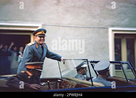 Ein Auto mit jugoslawischem Präsidenten Tito zu einem Besuch in Postojna, Slowenien im Jahr 1958. In den 1950er Jahren war diese Region Teil Jugoslawiens, 1991 wurde Slowenien ein unabhängiges Land. In Militäruniform steht Tito, um die Menschen auf der Straße anzuerkennen. Bei ihm sitzt der äthiopische Kaiser Haile Selassie. Tito (Josip Broz – 1892–1980) war ein jugoslawischer Staatsführer von 1943 bis zu seinem Tod. Haile Selassie I. (1892–1975) war von 1930 bis 1974 Kaiser von Äthiopien. Dieses Bild stammt von der 35 mm Farbdurchlässigkeit eines Amateurschauers – einem Vintage-Foto aus den 1950er Jahren. Stockfoto