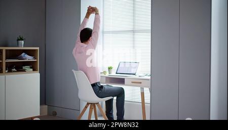 Glückliche junge Geschäftsmann streckte seine Arme im Büro Stockfoto