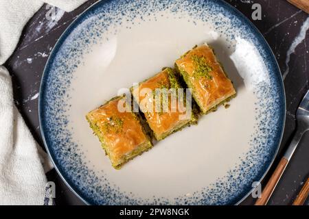 Baklava mit Pistazien auf dunklem Hintergrund. Traditionelles türkisches Baklava. Draufsicht Stockfoto