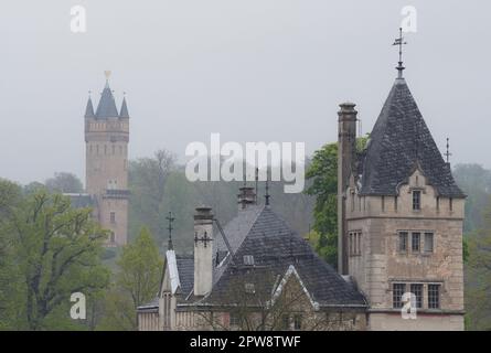 Potsdam, Deutschland. 29. April 2023. Morgennebel liegt über dem Havelhaus (r) und dem Flatow Tower im Babelsberg Park. Das Havelhaus aus dem Jahr 1843 ist eines der ältesten Gebäude in Potsdam. Der Flatow Tower, der Mitte des 19. Jahrhunderts erbaut wurde, ist ein Wahrzeichen der Gartenlandschaft Babelsberg und bietet einen wunderschönen Blick von der Aussichtsplattform. Kredit: Soeren Stache/dpa/Alamy Live News Stockfoto