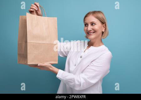 Zufriedene Frau mittleren Alters mit brauner Handwerkstasche Stockfoto