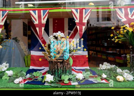 Patriotische Schaufensterausstellung mit Union Jack-Fahnenzug und Fahne sowie eine goldene Krone für die Krönung von König Karl 3. Stockfoto