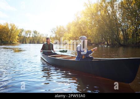 Kajakfahren als Paar. Ein junges Paar, das eine Kanufahrt auf dem See macht. Stockfoto
