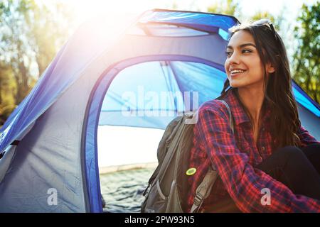 Ich übernehme das einen Tag im Einkaufszentrum. Eine attraktive junge Frau, die auf ihrem Campingplatz sitzt. Stockfoto