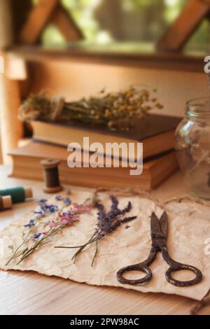 Komposition mit schönen getrockneten Blumen und Papier auf Holztisch Stockfoto