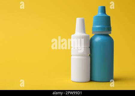 Flaschen medizinischer Tropfen auf gelbem Hintergrund. Platz für Text Stockfoto