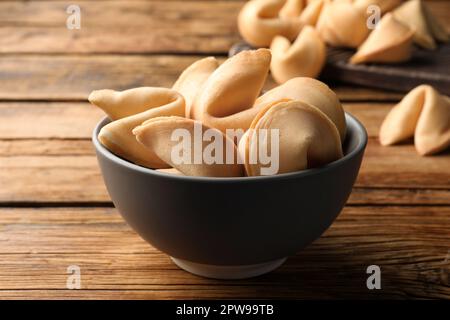 Leckere Glückskekse mit Voraussagen auf Holztisch, Nahaufnahme Stockfoto