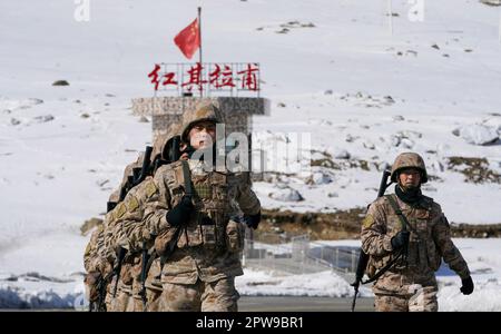 (230429) -- KHUNJERAB, 29. April 2023 (Xinhua) -- Soldatenpatrouille in Khunjerab, Nordwestchina, Uygur Autonome Region Xinjiang, 13. April 2023. Gao Guanghui, ein Rekrut, der erst seit 7 Monaten der Armee beigetreten war, war schockiert, als er den Ehrenraum des Grenzverteidigungsregiments in Khunjerab im Nordwesten Chinas Uygur Autonomer Region Xinjiang betrat. Das Regiment basiert auf den Pamiren und bewacht die China-pakistanische Grenze und den Hafen von Khunjerab. Mit einer durchschnittlichen Höhe von 4.700 Metern ist der Ort für viele Menschen eine „verbotene Zone“, da die Temperatur hier auf bis zu minus 40 Grad sinken kann Stockfoto