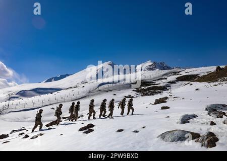 (230429) -- KHUNJERAB, 29. April 2023 (Xinhua) -- Soldatenpatrouille in Khunjerab, Nordwestchina, Uygur Autonome Region Xinjiang, 13. April 2023. Gao Guanghui, ein Rekrut, der erst seit 7 Monaten der Armee beigetreten war, war schockiert, als er den Ehrenraum des Grenzverteidigungsregiments in Khunjerab im Nordwesten Chinas Uygur Autonomer Region Xinjiang betrat. Das Regiment basiert auf den Pamiren und bewacht die China-pakistanische Grenze und den Hafen von Khunjerab. Mit einer durchschnittlichen Höhe von 4.700 Metern ist der Ort für viele Menschen eine „verbotene Zone“, da die Temperatur hier auf bis zu minus 40 Grad sinken kann Stockfoto