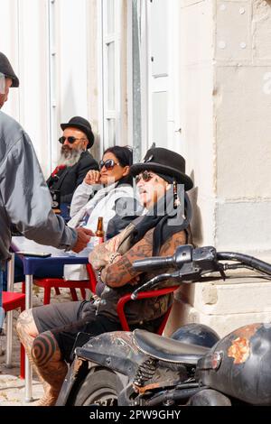 Tätowierter Mann mit Hut genießt die Sonne und trinkt Bier in loule portugal Stockfoto