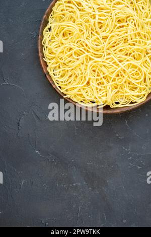 Top View leckere Spaghetti in der Schüssel auf schwarzem Hintergrund Kopierplatz Stockfoto