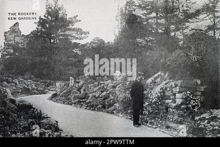 Nach London. Etwa 1905. Eine antike Postkarte mit dem Titel „The Rockery, Kew Gardens“, auf der ein Constabulary der königlichen Botanischen Gärten dargestellt ist, der durch die Felsengegend der Kew Gardens spaziert. Der 1840 gegründete Kew Gardens ist ein botanischer Garten im Südwesten Londons und soll die größte und vielfältigste botanische und mykologische Sammlung der Welt beherbergen. Seit 1845 betreibt Kew Gardens eine eigene Polizei, die heute als Kew Constabulary bekannt ist. Stockfoto