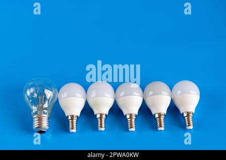 Energiesparende LED-Lampen mit Glühlampe in einer Reihe auf blauem Hintergrund. Das Konzept der Energieeinsparung. Schließen. Stockfoto