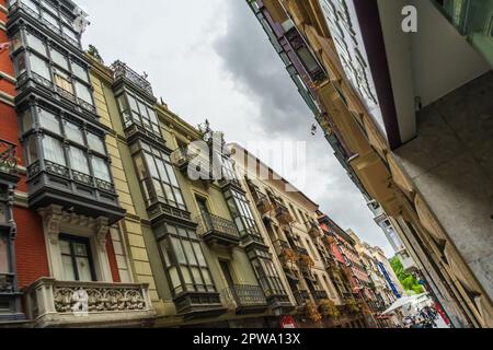 Bilbao, Spanien - 10.06.2022: Enge Gassen mit farbenfrohen Balkonen, Blickwinkel Stockfoto