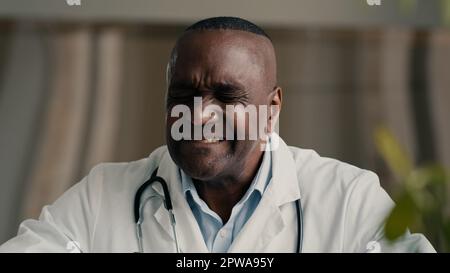 Afrikanischer ethnischer Arzt Arzt Arzt Halsschmerzen leiden an entzündeten Mandeln ungesunder reifer Mann verletzt Schluck hat COvid-19 Krankheit Symptom Stockfoto