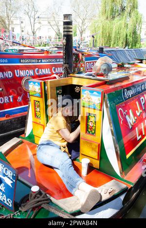 London, Vereinigtes Königreich, 29. April 2023: Auf der 40. Jährlichen Canalway Cavalcade in Londons Little Venice verleiht Nicola der Lackierung des Bootes EMU einen neuen Touch. Familienveranstaltungen und verschiedene Wettbewerbe zwischen Bootsbesitzern finden während des gesamten Feiertagswochenendes statt. Anna Watson/Alamy Live News. Stockfoto