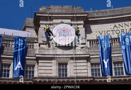 London, Großbritannien. 29. April 2023 Vor der Krönung von König Karl III., die am 6. Mai stattfindet, installieren die Arbeiter am Admiralty Arch in der Mall ein riesiges Krönungszeichen. Kredit: Vuk Valcic/Alamy Live News Stockfoto