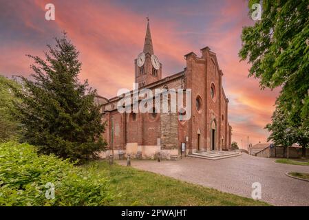 Pinerolo, Turin, Piemont, Italien - 29. April 2023: Mittelalterliche Kirche San Maurizio aus dem 13. Jahrhundert mit farbenfrohem Himmel bei Sonnenuntergang Stockfoto