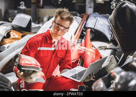 Ein alter Lagermitarbeiter für Gebrauchtwagenteile, der den Bestand in der Garage überprüft. Mitarbeiter, die in der Verwaltung von Autoteilen für den Recycling-Schrottplatz arbeiten. Stockfoto